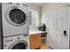 Convenient laundry room features a stacked washer and dryer unit and built in storage at 15972 W 70Th Dr, Arvada, CO 80007