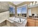 Bright main bathroom showcases a luxurious soaking tub with views at 15972 W 70Th Dr, Arvada, CO 80007