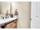 Stylish powder room with a modern vanity, quartz countertop, and a decorative mirror at 15972 W 70Th Dr, Arvada, CO 80007