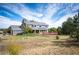 A vast lawn leads to a blue and brick home with a large deck and plentiful foliage at 19052 E Briarwood Dr, Centennial, CO 80016