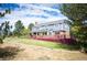 Spacious backyard view with a multi-level deck, lush lawn, mature trees, and scenic landscaping at 19052 E Briarwood Dr, Centennial, CO 80016