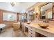 Bright bathroom featuring dual sinks, a glass shower, and a soaking tub next to a window with shutters at 19052 E Briarwood Dr, Centennial, CO 80016