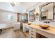 Bright bathroom featuring dual sinks, a glass shower, and a soaking tub next to a window with shutters at 19052 E Briarwood Dr, Centennial, CO 80016
