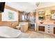 Bathroom featuring a glass shower, soaking tub, and dual sinks on a vanity beneath large framed mirrors at 19052 E Briarwood Dr, Centennial, CO 80016