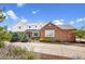 Charming brick and siding home with manicured landscaping and mature trees under a sunny sky at 19052 E Briarwood Dr, Centennial, CO 80016