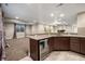 Basement bar area with dark wood cabinets, wine refrigerator, and tile flooring at 1775 Catnap Ln, Monument, CO 80132