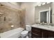 This bathroom features a modern vanity, granite countertop, and tiled shower and bathtub combination at 1775 Catnap Ln, Monument, CO 80132