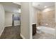 Bathroom and bedroom view with tan tile floors, tub, granite counter and gray walls at 1775 Catnap Ln, Monument, CO 80132
