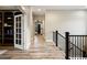 Open hallway with elegant wood flooring, black wrought iron railing and access to other rooms at 1775 Catnap Ln, Monument, CO 80132