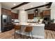 Kitchen featuring an island with barstool seating, wood beams, and stainless steel appliances at 1775 Catnap Ln, Monument, CO 80132