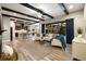 Open-concept living room with wood-beamed ceiling, hardwood floors, and a modern kitchen in the background at 1775 Catnap Ln, Monument, CO 80132