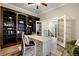 Bright home office featuring custom built-in shelving, french doors, and ample natural light at 1775 Catnap Ln, Monument, CO 80132