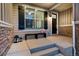 Cozy front porch with a bench, decorative lanterns, and stylish stonework accents at 1775 Catnap Ln, Monument, CO 80132