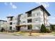 Modern condo building with grey siding, well-maintained landscaping, and a clear blue sky at 1585 Hecla Way # 201, Louisville, CO 80027