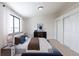 Staged bedroom features a large window, king bed, closet, and blue accents for a relaxing retreat at 12425 Albion St, Thornton, CO 80241