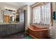 Stylish bathroom showcasing a unique copper bathtub, granite countertops, and natural wood accents at 5800 Elk View Ct, Larkspur, CO 80118