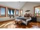 Vaulted bedroom suite with lots of natural light and mountain views from large windows at 5800 Elk View Ct, Larkspur, CO 80118