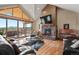 Spacious living room featuring a stone fireplace, vaulted ceilings, and deck access at 5800 Elk View Ct, Larkspur, CO 80118