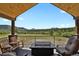 Inviting outdoor deck with vaulted ceiling, mountain views, and seating area around fire pit at 5800 Elk View Ct, Larkspur, CO 80118