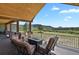 Spacious outdoor deck with vaulted ceiling, beautiful mountain views and cozy seating area around fire pit at 5800 Elk View Ct, Larkspur, CO 80118