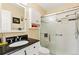 Bathroom featuring white cabinets, a black countertop, and a shower with glass doors at 9598 Lowell Blvd, Westminster, CO 80031