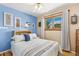 Cozy bedroom with a large window, blue accent wall, neutral colors, and wood floors at 9598 Lowell Blvd, Westminster, CO 80031