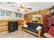 Basement bedroom with futon, wood paneling, and natural light from egress window at 9598 Lowell Blvd, Westminster, CO 80031