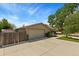 Charming single-story home featuring a wide driveway, neutral stucco, brick accents, and mature landscaping at 9598 Lowell Blvd, Westminster, CO 80031