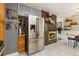 View of a modern kitchen with stainless steel refrigerator and brick fireplace at 9598 Lowell Blvd, Westminster, CO 80031