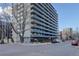 Exterior view of a high-rise apartment building with many balconies and street parking at 909 N Logan St # 1B, Denver, CO 80203