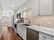 Contemporary kitchen features stainless steel appliances, white cabinetry, and tiled backsplash at 909 N Logan St # 1B, Denver, CO 80203