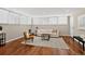 Cozy living room featuring wood floors, neutral walls, and natural light from large windows with white blinds at 909 N Logan St # 1B, Denver, CO 80203