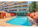 Apartment building pool with lounge chairs, surrounded by mature landscaping and colorful walls at 909 N Logan St # 1B, Denver, CO 80203