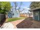 Backyard with tidy storage shed, turf lawn, and a stone patio, perfect for outdoor enjoyment and storage at 4933 Grove St, Denver, CO 80221