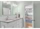 Bathroom with a double vanity with granite countertop, bright lighting and view to dining room at 4933 Grove St, Denver, CO 80221