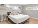 Bright bedroom with hardwood floors, a comfortable bed, and natural light from three windows at 4933 Grove St, Denver, CO 80221