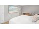 Bright bedroom showcasing soothing beach-themed art, a dresser, and a comfortable bed with plush pillows at 4933 Grove St, Denver, CO 80221