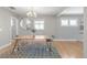 Bright dining room featuring a modern chandelier, wood table and clear seating with an octagon mirror at 4933 Grove St, Denver, CO 80221