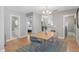 Light filled dining area with a chandelier, wood table and seating for four, with views to the kitchen at 4933 Grove St, Denver, CO 80221