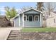 Charming blue home featuring a well-kept lawn, stone wall, and inviting front porch at 4933 Grove St, Denver, CO 80221
