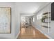 Inviting hallway with hardwood floors leading to the dining area and kitchen with an decorative art piece at 4933 Grove St, Denver, CO 80221