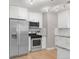Modern kitchen featuring stainless steel appliances, white cabinetry, and a granite countertop at 4933 Grove St, Denver, CO 80221