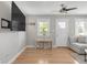 Bright living room with hardwood floors, a ceiling fan and a wall-mounted television with natural light at 4933 Grove St, Denver, CO 80221