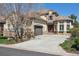 Charming two-story home featuring stone accents, a curved driveway, and mature landscaping at 35 Brookhaven Pl, Littleton, CO 80123