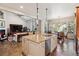 Open-concept kitchen island with granite countertop with pendant lighting, seamlessly connecting to the living and dining areas at 35 Brookhaven Pl, Littleton, CO 80123