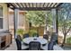 Charming outdoor dining area with pergola, featuring a round table, seating, and lush landscaping at 35 Brookhaven Pl, Littleton, CO 80123