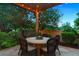 Outdoor dining area with a round table, comfortable wicker chairs, and a stone patio at 35 Brookhaven Pl, Littleton, CO 80123