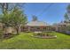 Lush backyard featuring green lawn, mature tree, and brick-bordered garden beds at 5703 Ammons St, Arvada, CO 80002