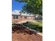 Well-maintained backyard with lush lawn, garden beds, patio, and a charming brick home exterior at 5703 Ammons St, Arvada, CO 80002