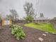 Landscaped backyard featuring a garden, shed, and brick house in a serene, fenced setting at 5703 Ammons St, Arvada, CO 80002
